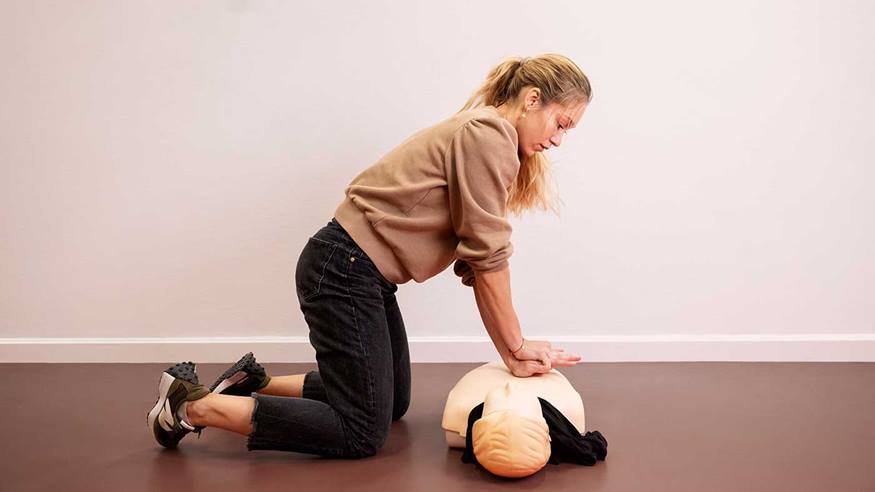  Kvinde der yder hjertelungeredning på en førstehjælpsdukke