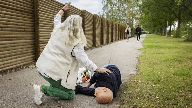  Kvinde der signalerer, at hun har brug for hjælp ved en mand, der er faldet om