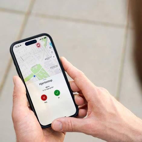 En mand kigger på sin telefon, hvor han har fået en hjerteløber-alarm i hjerteløber-appen